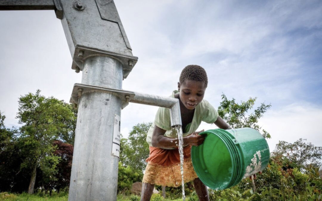 young boy getting clean water in zambia