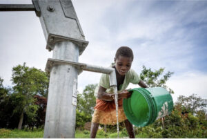 young boy getting clean water in zambia